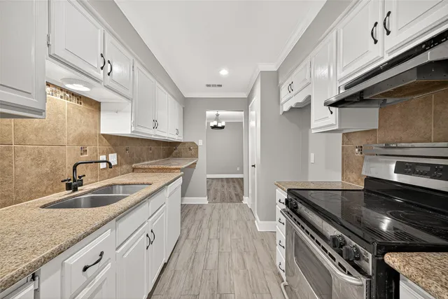 a kitchen with stainless steel appliances granite countertop a sink stove and cabinets