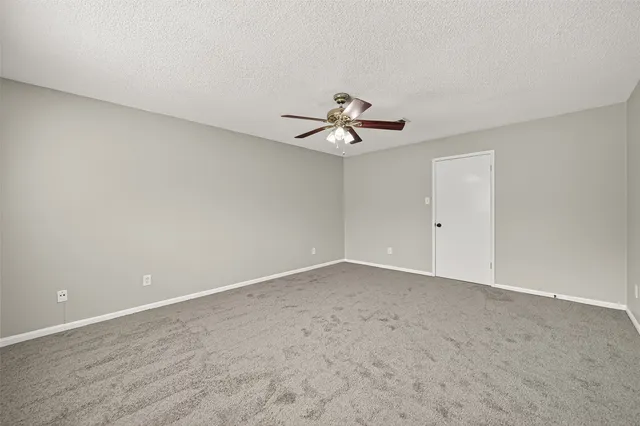 a view of an empty room with a ceiling fan