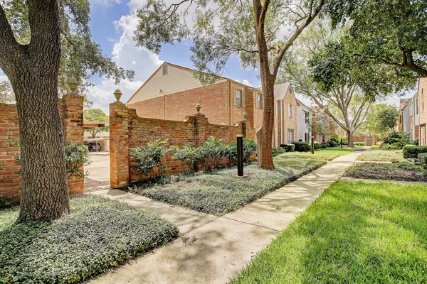 a view of a street with a tree in the grass