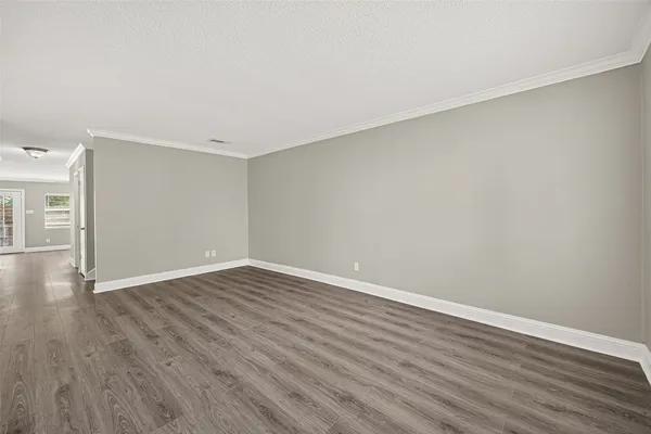 a view of an empty room with wooden floor