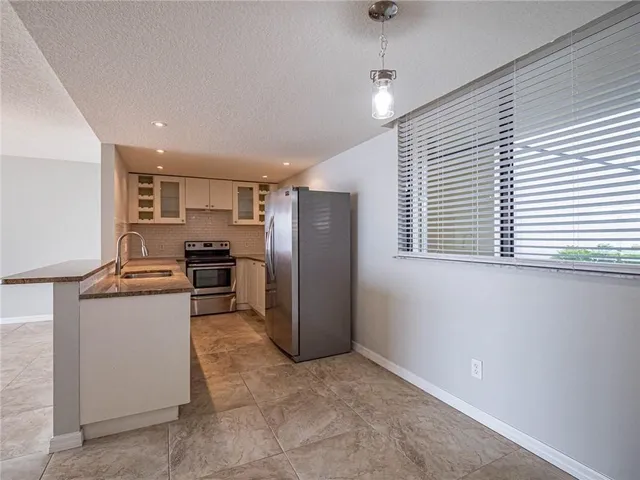 a kitchen with a refrigerator and a stove top oven