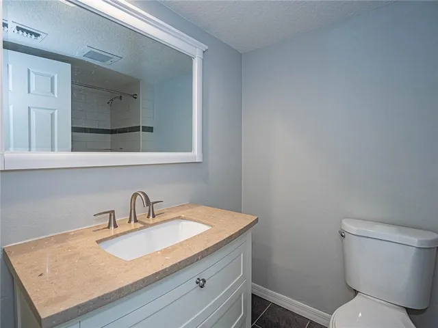 a bathroom with a toilet a sink and mirror
