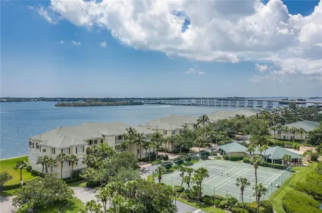 an aerial view of a city with lots of residential buildings and ocean view in back