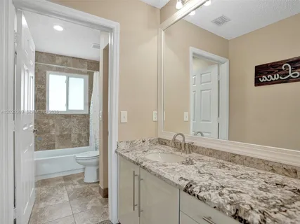 a kitchen with granite countertop a sink stainless steel appliances and cabinets