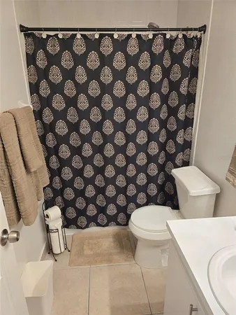 a white toilet sitting next to a shower curtain