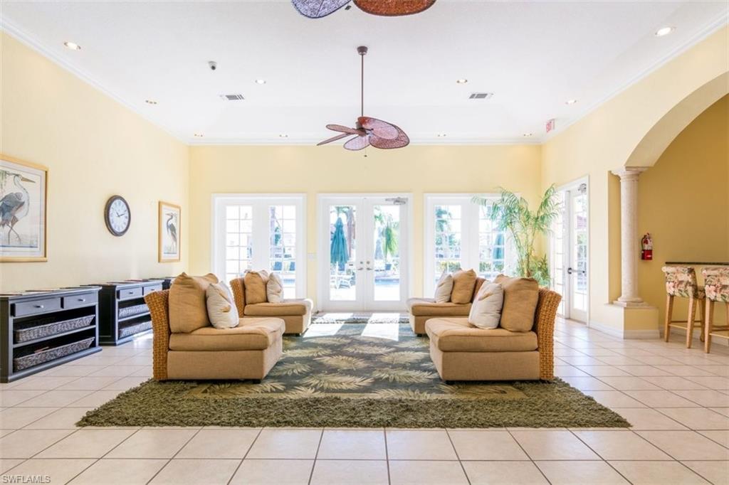 4635 St Croix Lane, Unit 1218 Naples, FL 34109 - Photo 30 of 40 Living area featuring arched walkways, light tile patterned flooring, french doors, crown molding, and a ceiling fan