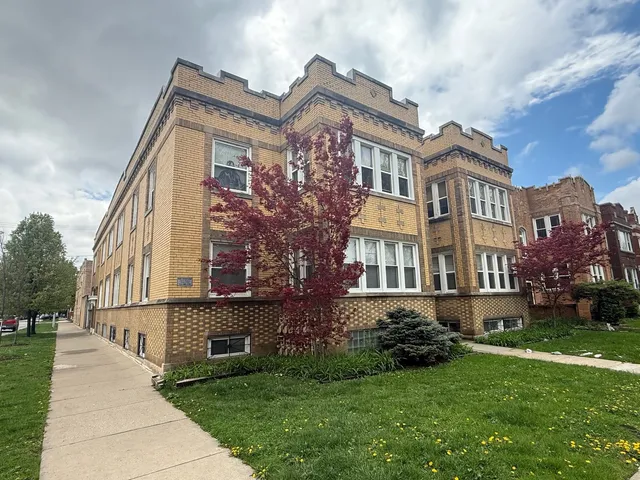 a front view of a residential apartment building with a yard