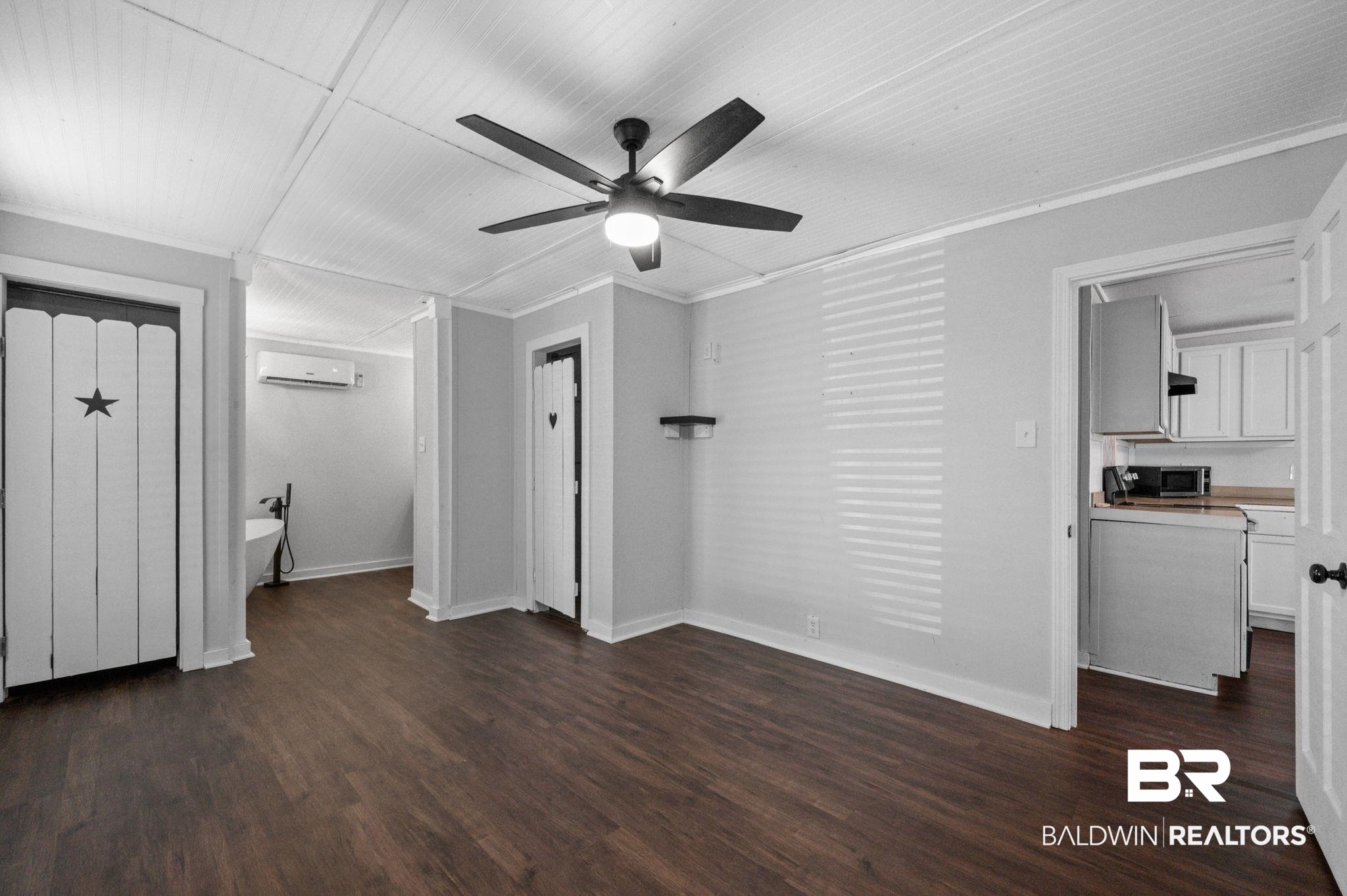 503 North Holly Street Foley, AL 36535 - Photo 12 of 23 Interior space with dark wood-type flooring, a wall mounted AC, crown molding, and ceiling fan