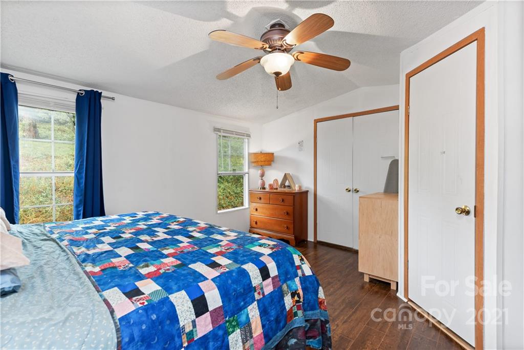 3 Buckner Road Leicester, NC 28748 - Photo 11 of 28 a bedroom with a bed and a chandelier