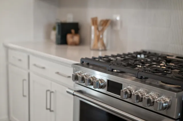 a living room with stainless steel appliances furniture refrigerator and a large window