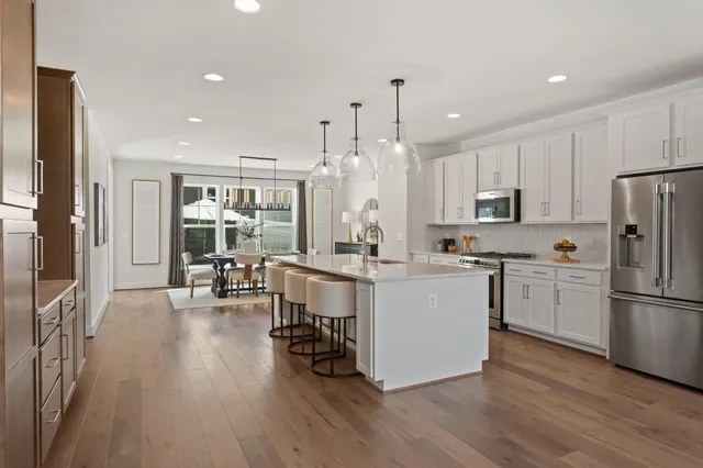 a kitchen with kitchen island white cabinets and stainless steel appliances