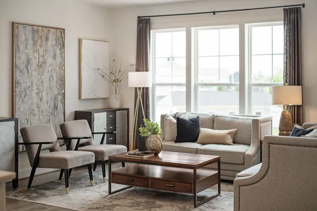 a living room with furniture flat screen tv and a large window
