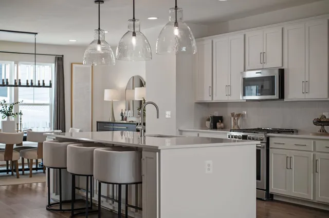 a kitchen with kitchen island granite countertop a table chairs microwave and cabinets