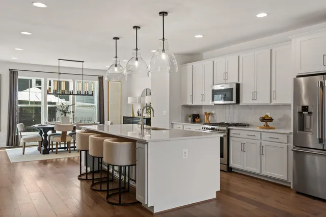 a kitchen with appliances a sink a counter top space and a center island