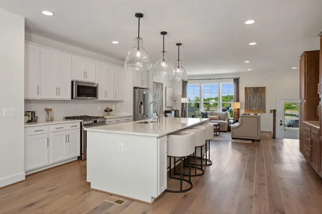 a kitchen with granite countertop a sink a counter space appliances and cabinets