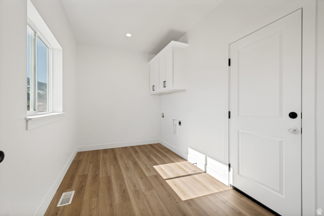 1351 Maple Circle Santaquin, UT 84655 - Photo 16 of 42 Spacious utility room featuring wood-finish flooring, white walls, recessed ceiling lighting, a window with mountain scenery, and built-in white cabinetry with matte black hardware