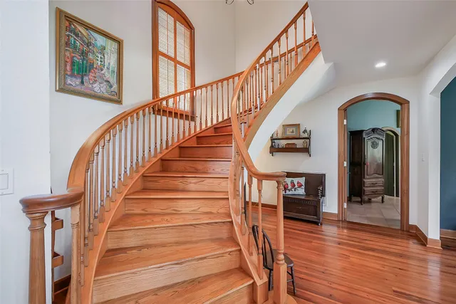 a view of staircase with wooden floor and a chandelier