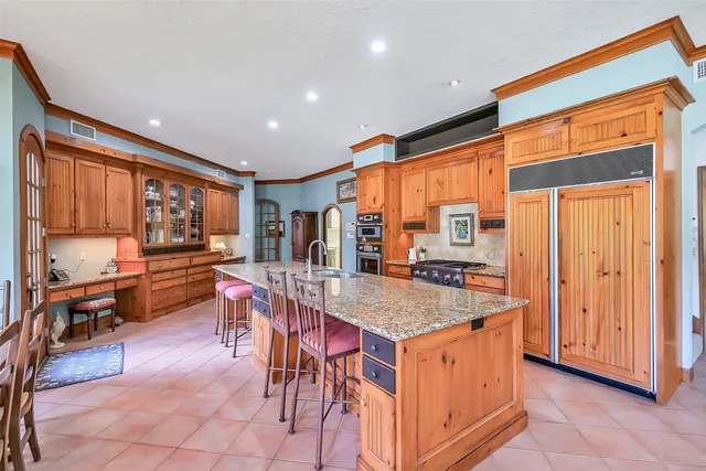 a kitchen with stainless steel appliances granite countertop a stove a sink dishwasher and a refrigerator