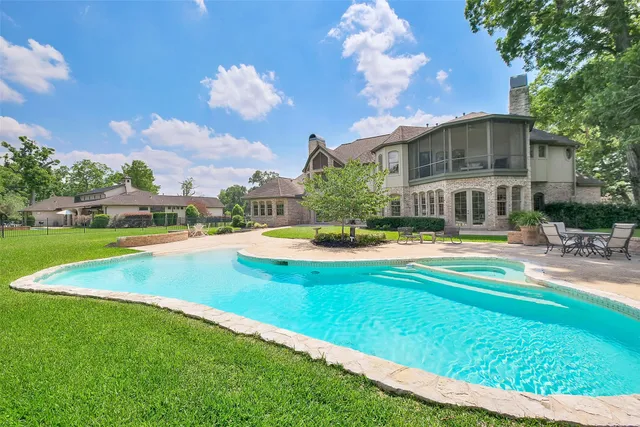 a view of a lake with a yard and large trees