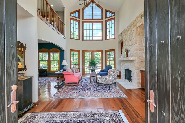 a living room with furniture fireplace and a large window