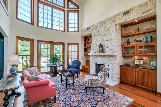 a living room with furniture a fireplace and large windows