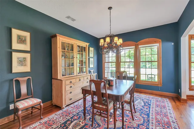 a dining room with furniture a chandelier and wooden floor