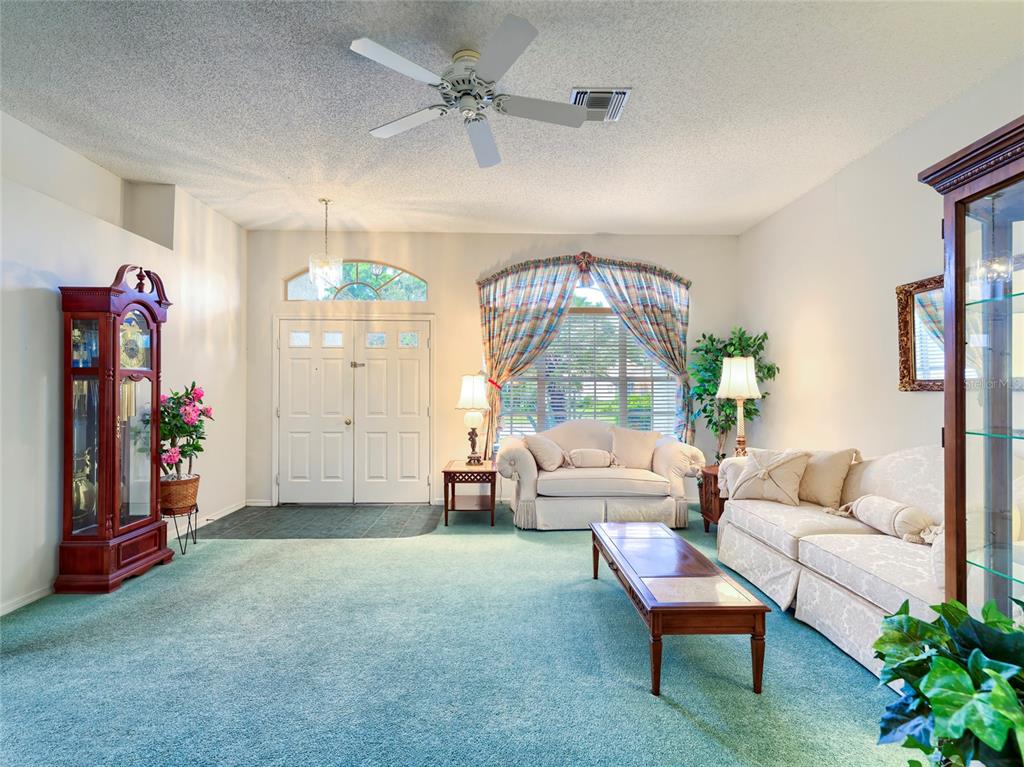 11228 Windrush Circle Hudson, FL 34667 - Photo 17 of 67 a living room with furniture and a chandelier
