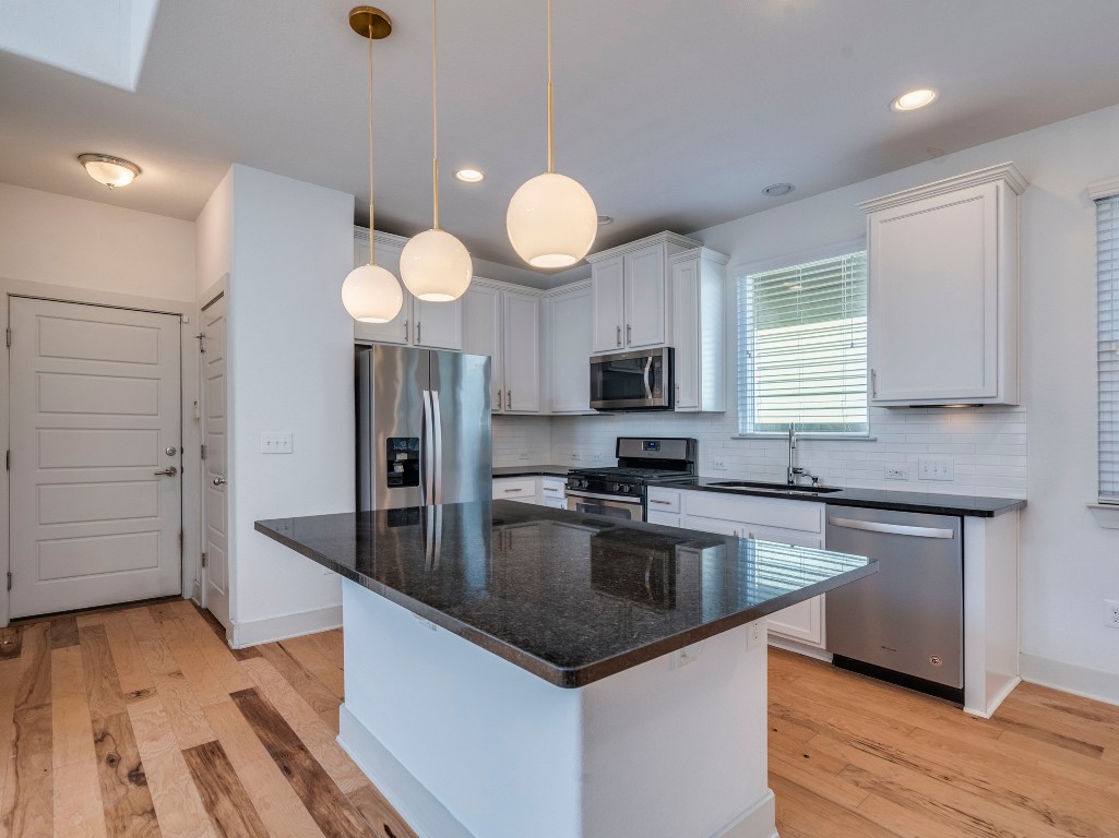 2309 Hermia Street Austin, TX 78741 - Photo 11 of 30 a kitchen with stainless steel appliances granite countertop a sink a stove and wooden floors