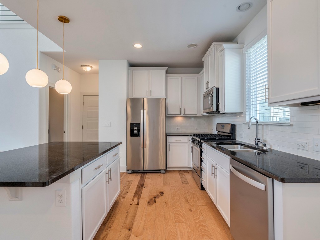 2309 Hermia Street Austin, TX 78741 - Photo 12 of 30 a kitchen with stainless steel appliances granite countertop a sink a stove and a refrigerator