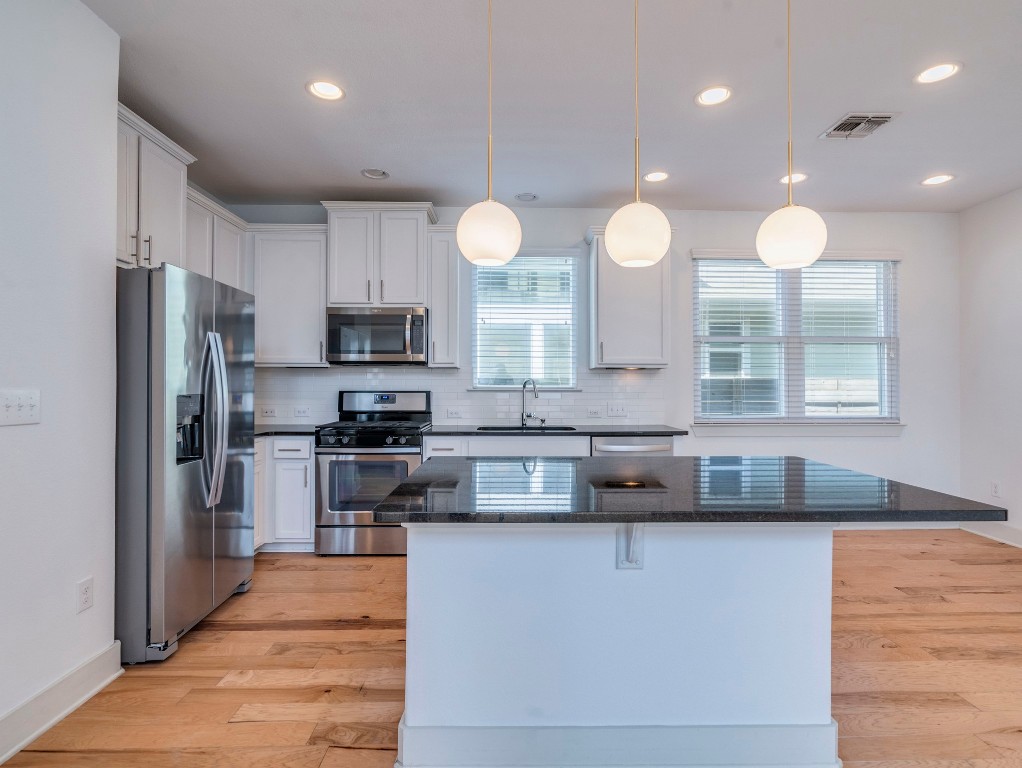 2309 Hermia Street Austin, TX 78741 - Photo 10 of 30 a kitchen with stainless steel appliances granite countertop a sink a stove a refrigerator and a microwave