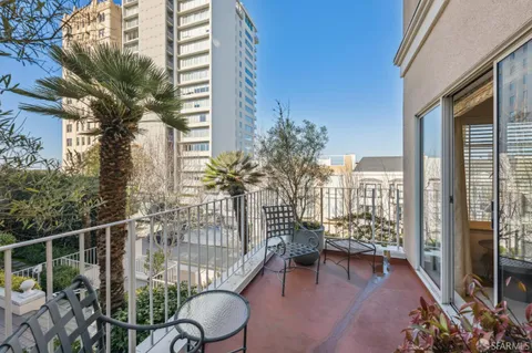 a balcony with chairs and with potted plants