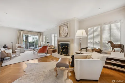 a living room with furniture a large window and a fireplace