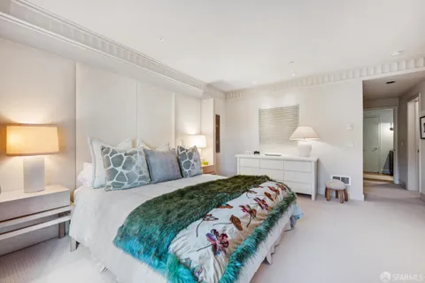 a spacious bedroom with a bed and a cabinets
