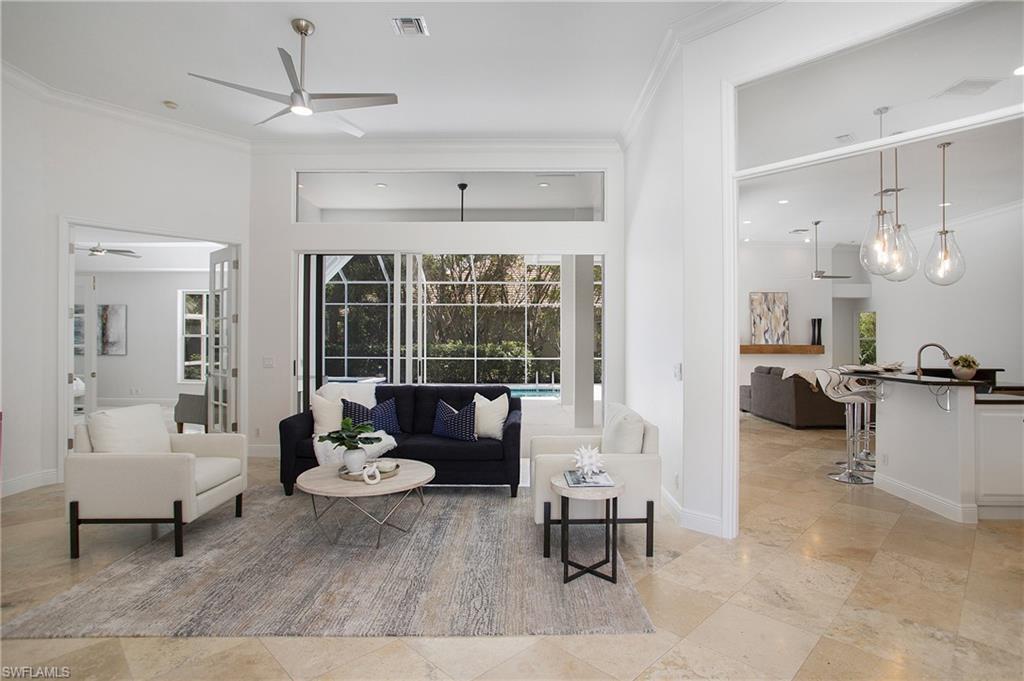 a living room with furniture and a large window with wooden floor