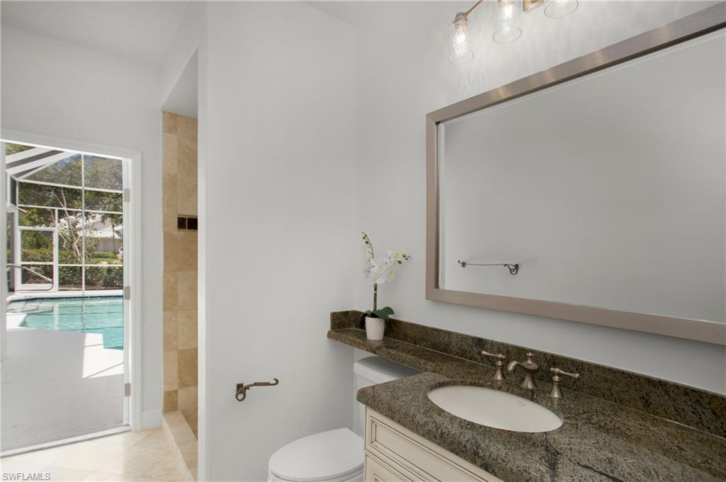 1984 Mission Drive Naples, FL 34109 - Photo 32 of 50 a bathroom with a granite countertop sink toilet a mirror and shower