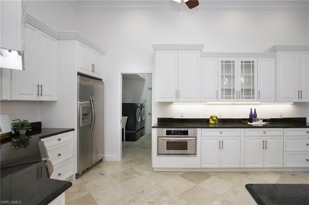 1984 Mission Drive Naples, FL 34109 - Photo 9 of 50 a kitchen with granite countertop a stove a sink a refrigerator and cabinets