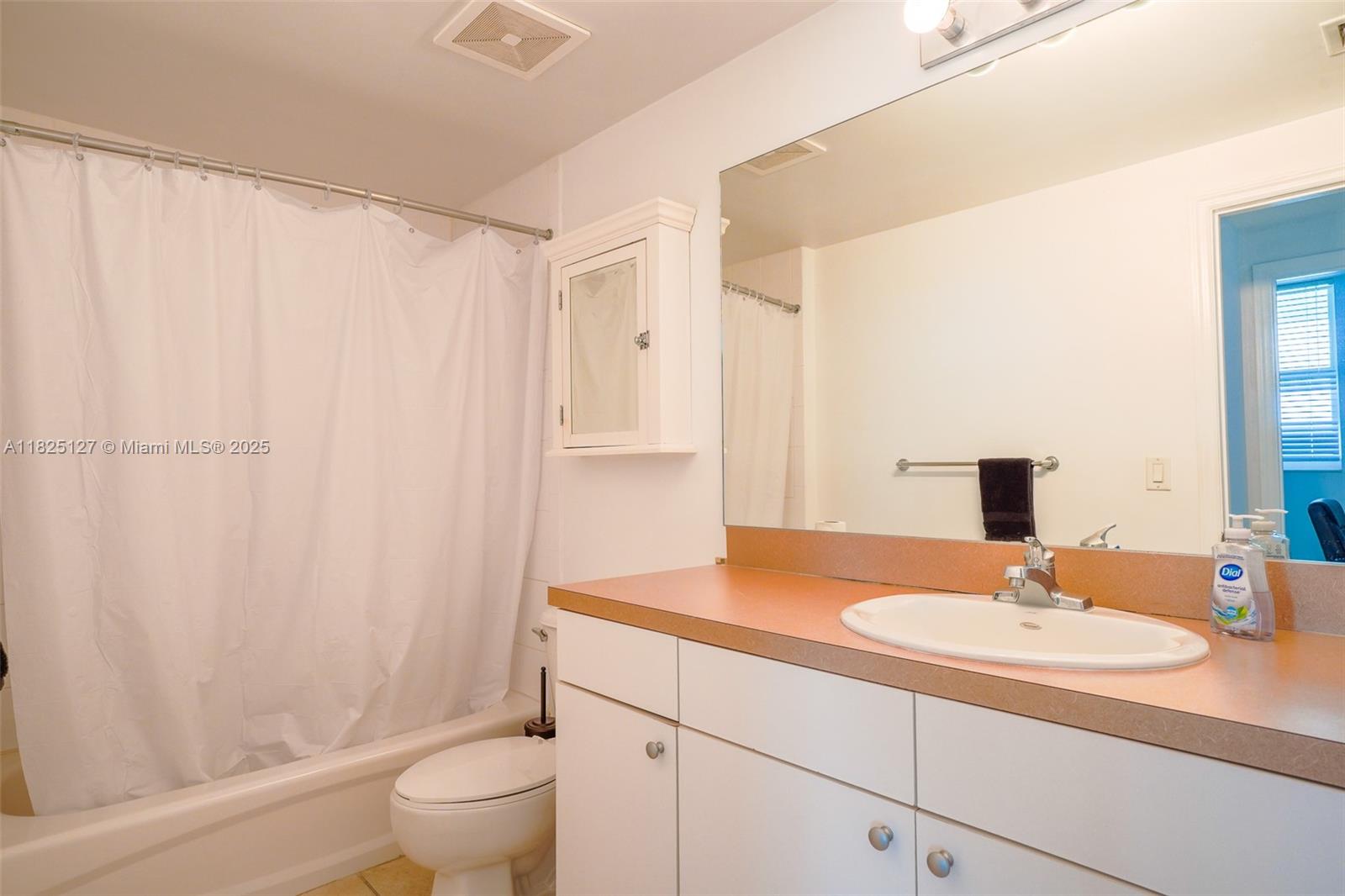 1250 South Miami Avenue, Unit 3003 Miami, FL 33130 - Photo 18 of 31 a bathroom with a sink toilet a mirror and shower curtain