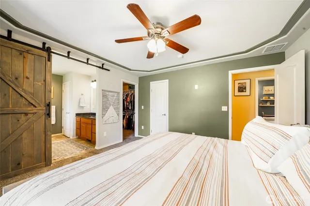 a bedroom with a large bed a flat tv screen and dresser