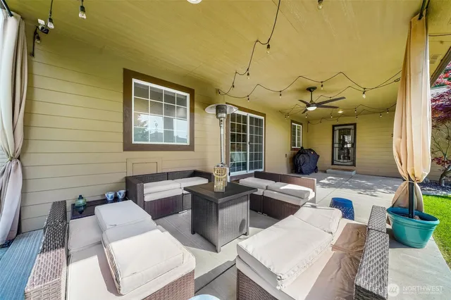 a living room with furniture a large window and wooden floor