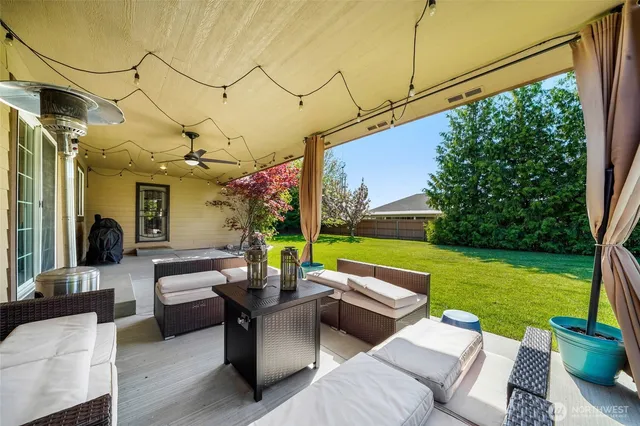 a view of a patio with couches potted plants and a big yard