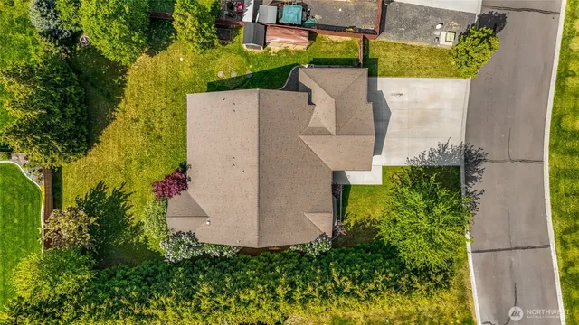 an aerial view of a house with a yard and a large tree