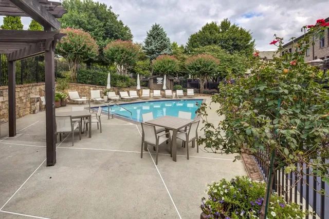 a view of a brick house with plants and wooden fence