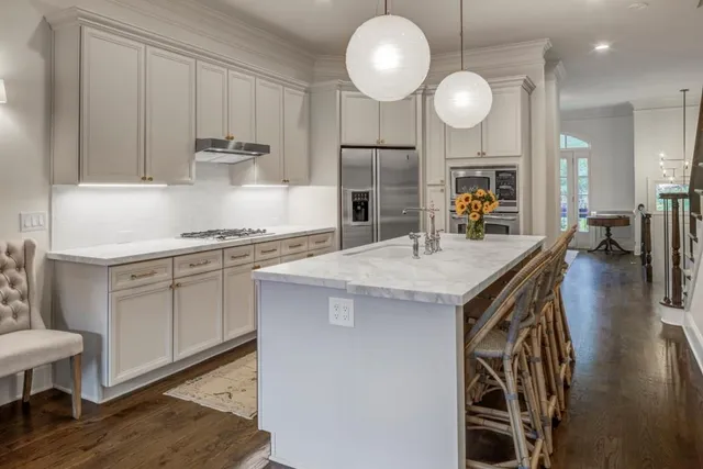 a kitchen with kitchen island a counter space a sink appliances and cabinets