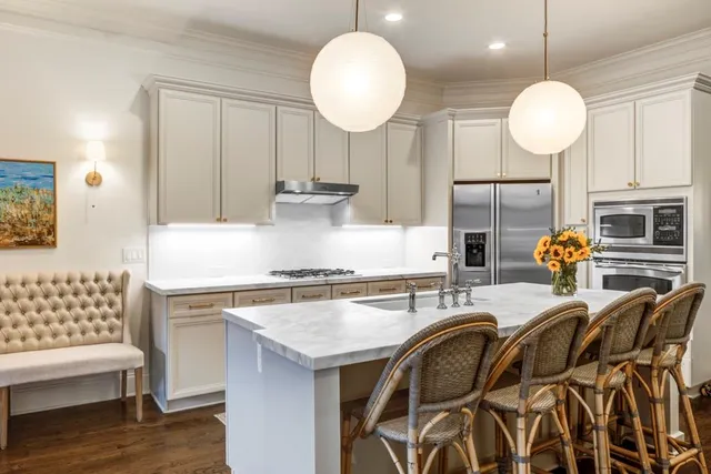 a kitchen with stainless steel appliances granite countertop a stove a sink and a chandelier