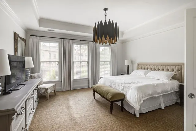 a spacious bedroom with a bed and a chandelier