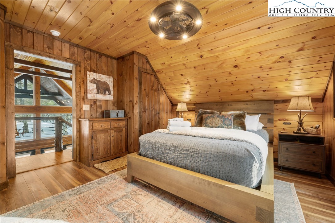 123 St Andrews Road Beech Mountain, NC 28604 - Photo 42 of 47 a spacious bedroom with a bed and wooden floor