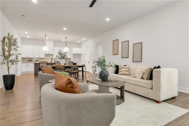 a living room with furniture and a wooden floor