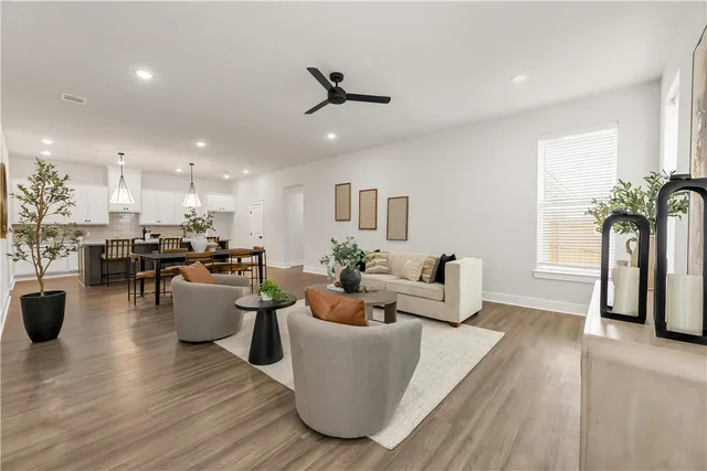 a living room with furniture and a view of kitchen