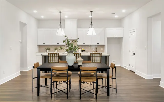 a living room with furniture kitchen view and a wooden floor