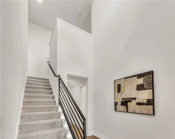 a view of a hallway with wooden floor and staircase